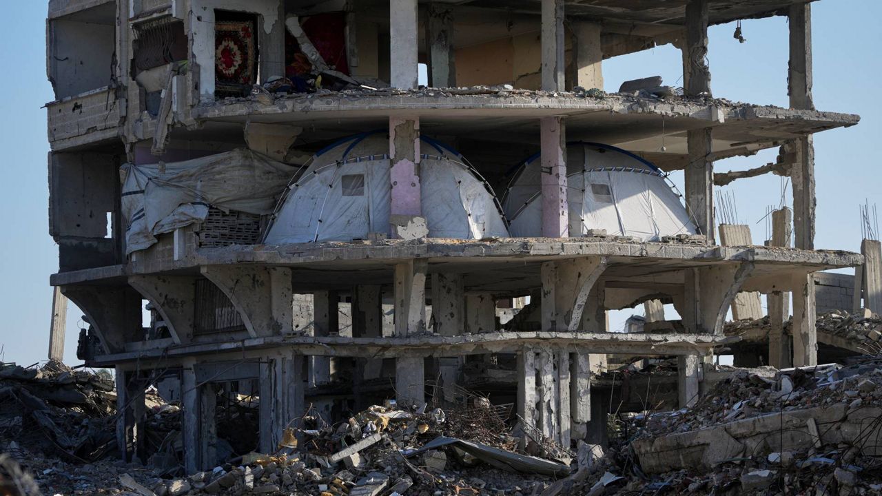 Muhannad Abu Muharib, 27, reinforces his tent after it was damaged by a storm at a temporary camp on the beach in Deir al-Balah, in the central Gaza Strip, Saturday, Nov. 15, 2025. (AP Photo/Abdel Kareem Hana)