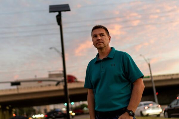 Alek Schott stands next to a Flock Safety license plate reader in his neighborhood, Thursday, Oct. 16, 2025, in Houston. (AP Photo/David Goldman)