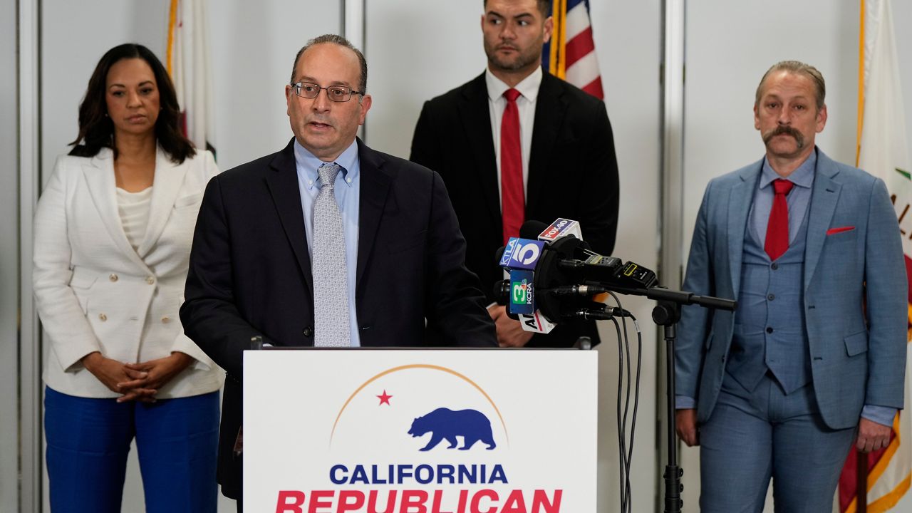 Dhillon Law Group partner Mike Columbo, second from left, speaks to reporters during a press conference announcing a federal lawsuit challenging Proposition 50 Wednesday in Sacramento, Calif. (AP Photo/Godofredo A. Vásquez)