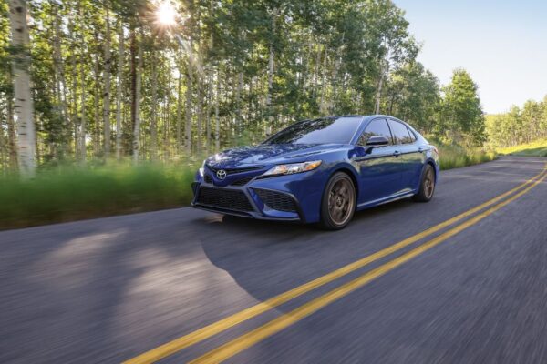 A blue 2024 Toyota Camry in the forest day.