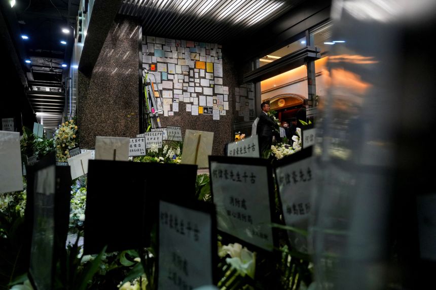 Condolence messages and flowers piled up outside a funeral for senior fireman Ho Wai-ho, who was killed in a deadly fire at the Wang Fuk Court housing complex in Tai Po, Hong Kong, on December 18, 2025.