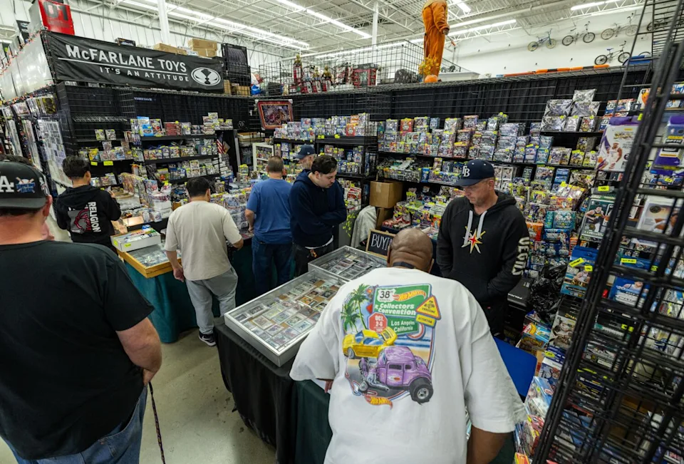 Customers browse and shop for cards at vendor Eric Mitchel's booth at Frank and Son Collectible Show.