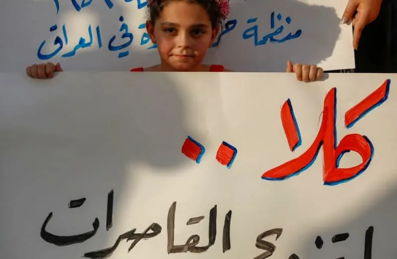 A girl holds a placard as activists demonstrate against female child marriages, in Tahrir Square in central Baghdad on July 28, 2024, amid parliamentary discussion over a proposed amendment to the Iraqi Personal Status Law. Rights advocates are alarmed by a bill introduced to Iraq's parliament that, (credit: Ahmad al-Rubaye/AFP via Getty Images)