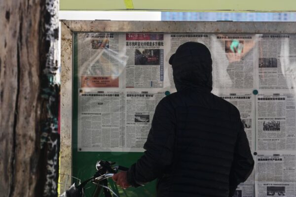 A resident reads local newspapers reporting on Japanese Prime Minister Sanae Takaichi's recent remarks on Taiwan, at a newsstand in Beijing, on November 17, 2025.