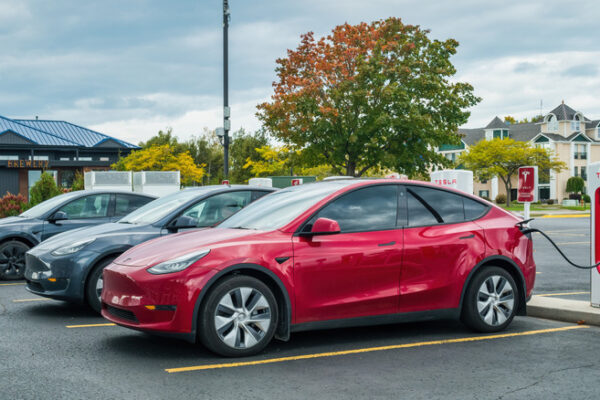 Several Tesla Model Ys at a Tesla charging station.