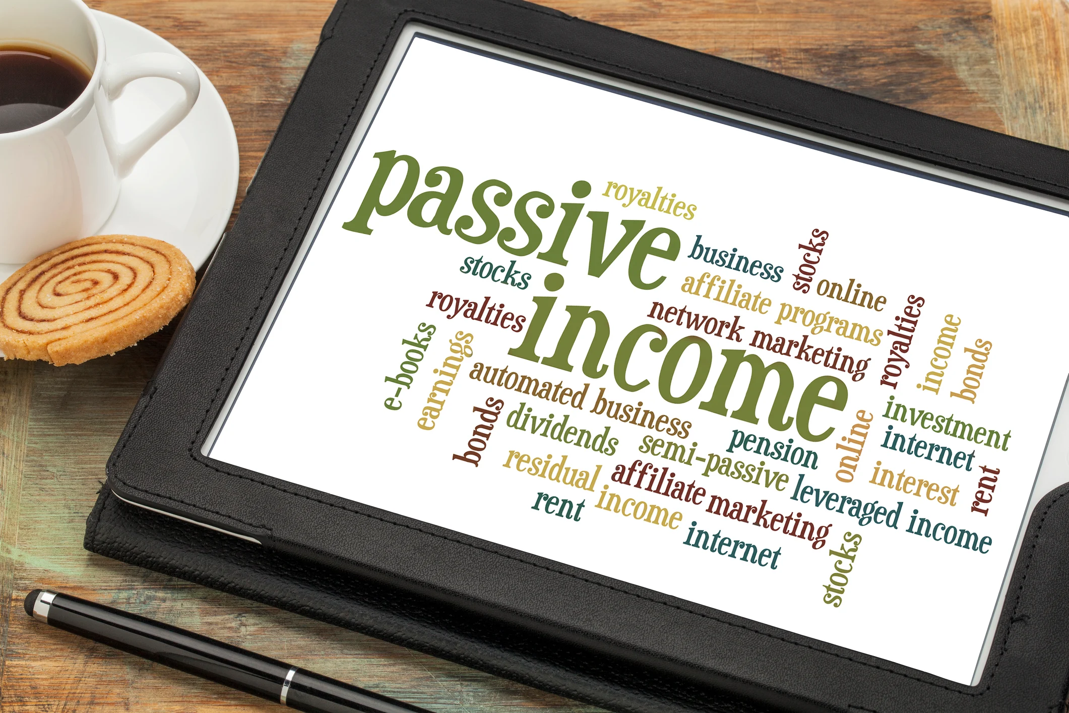 A tablet showing a word cloud prominently featuring "passive income."
