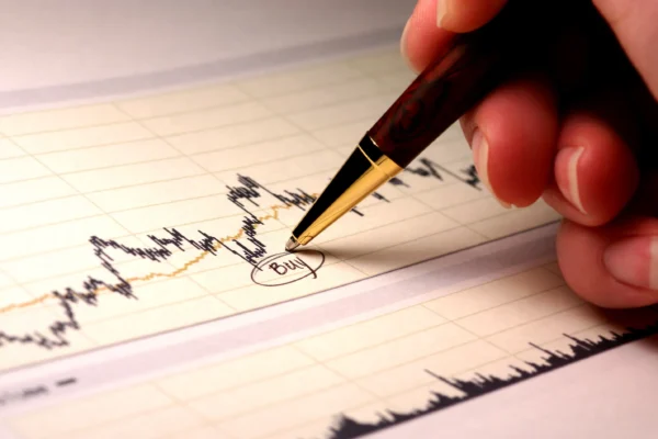 A pen points to the circled word "buy" written below a stock price chart.