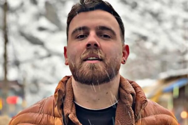 Erfan Soltani in an orange puffer jacket and woolen shirt.