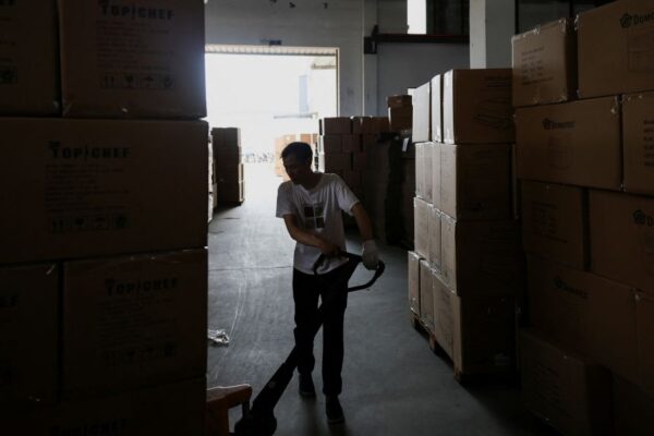 An employee of Gstar Electronic Appliance Co., Ltd moves finished products on a pulling cart in the factory in Ningbo, China, on May 19, 2025.