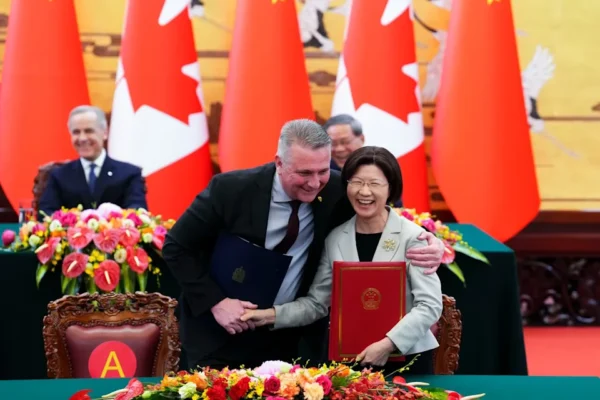 Canadian Prime Minister Mark Carney, back left, and Premier of China Li Qiang, back right, look on as Minister of Agriculture and Agri-Food Heath MacDonald, front left, and Sun Meijun, Minister of the General Administration of Customs in China take part in a signing ceremony at the Great Hall of the People in Beijing, China on Thursday, Jan. 15, 2026.