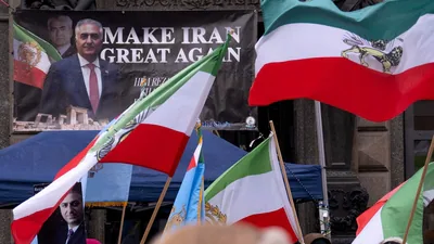 Protesters hold up placards featuring Reza Pahlavi, the son of the last shah of Iran, as they wave Pahlavi-era Iranian flags during a demonstration against the Iranian government at Stephansplatz square in Vienna, Austria, on January 11, 2026. (AFP)
