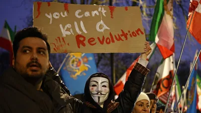 An anti-Iranian regime protester holds up a placard during a gathering outside the Iranian Embassy, central London, on January 9, 2026. (AFP)