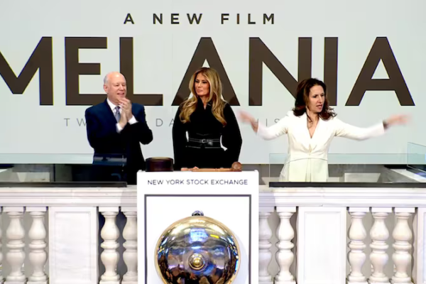 A woman gestures to the right of Melania Trump