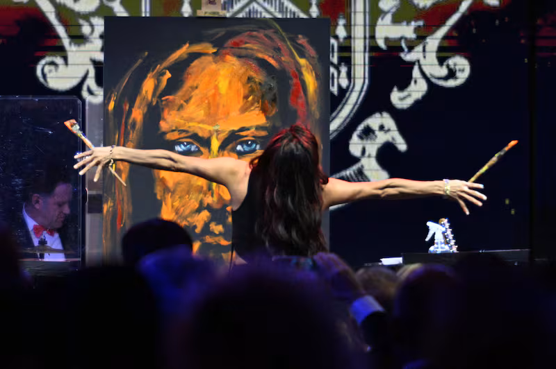 Christian speed artist Vanessa Horabuena paints a Jesus art piece during the New Year's Eve Party hosted by US President Donald Trump at his Mar-a-Lago residence in Palm Beach, Florida on December 31, 2025. (Photo by Jim WATSON / AFP via Getty Images)