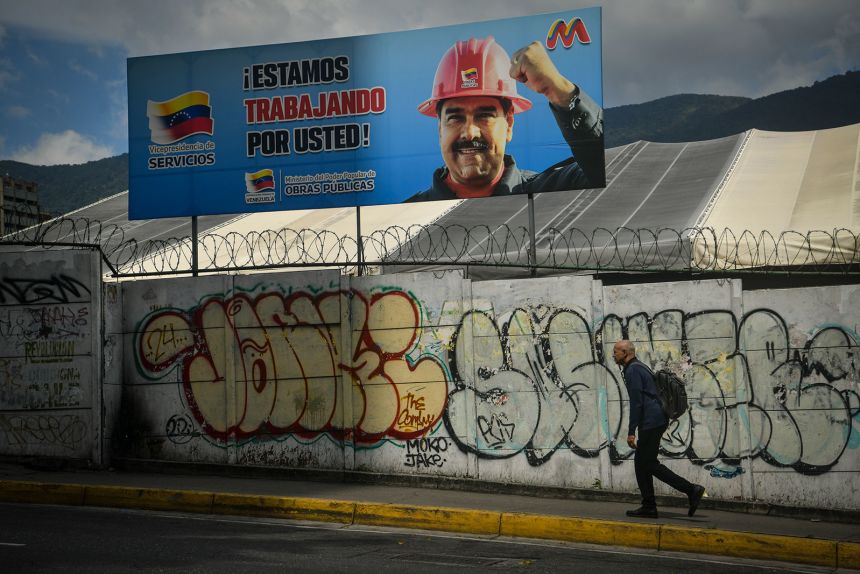 A man walks by a billboard of Nicolas Maduro on January 12, 2026 in Caracas, Venezuela. Venezuelan authorities have announced the liberation of 116 prisoners as part of the actions ordered by Nicolas Maduro prior to his capture by US forces.