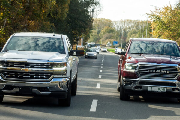 Front view of Chevrolet Silverado and Ram 1500 driving on street
