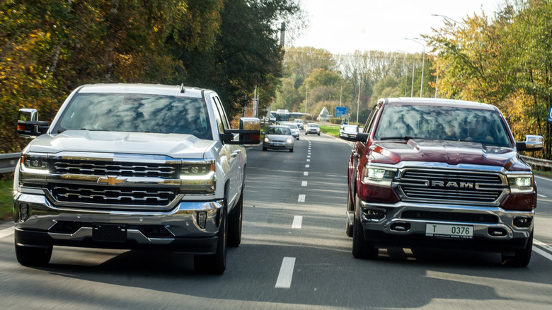 Front view of Chevrolet Silverado and Ram 1500 driving on street