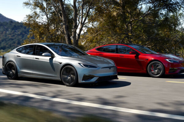 A silver and red Tesla Model S driving next to each other
