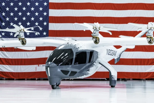 An Archer Aviation Midnight aircraft in front of an American flag.
