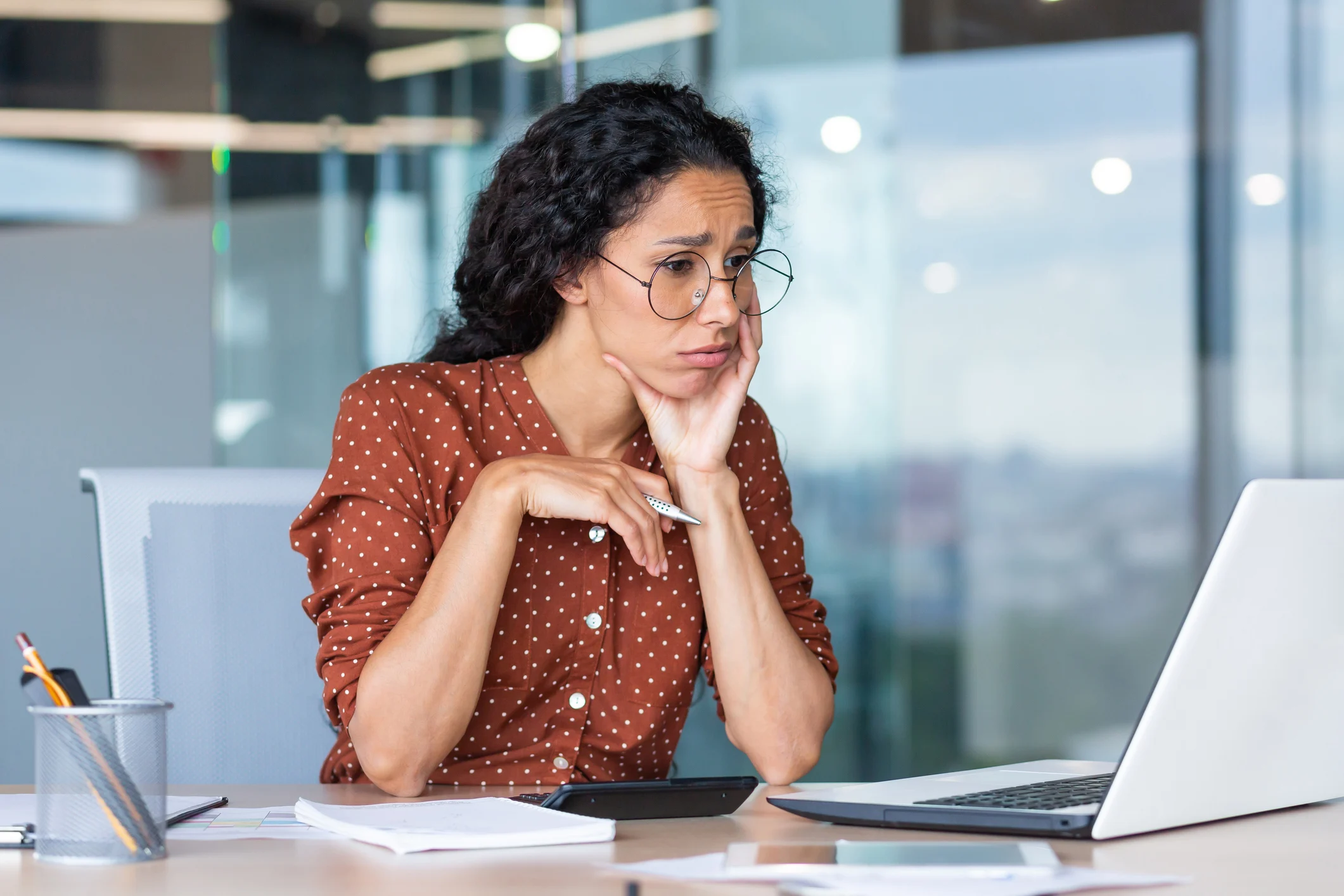 A person at a laptop looking unhappy.