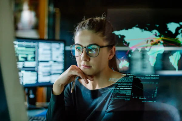 A person staring at graphs and charts on a computer monitor.