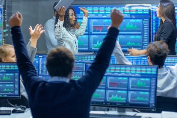Wall Street traders cheering with arms raised because the stock market went up.
