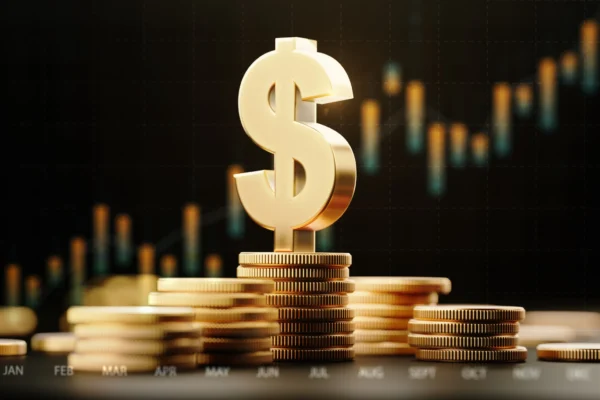A gold dollar sign on top of stacked gold coins in front of an upward-moving bar chart.