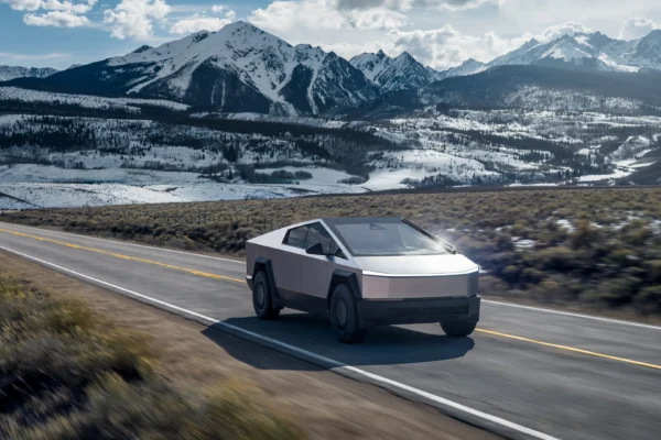 A Tesla Cybertruck driving on a highway in the mountains.