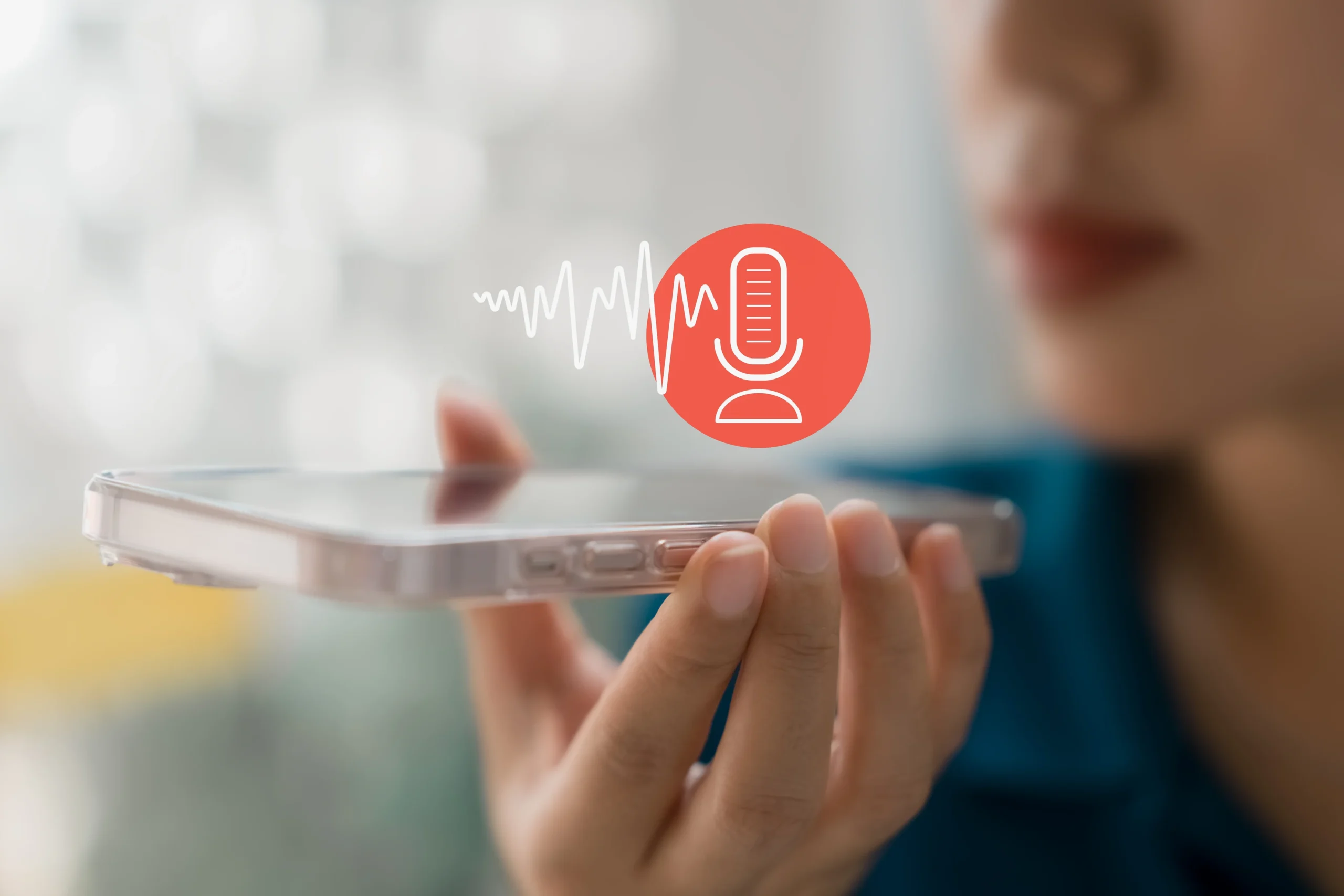 A person holding a smartphone with an image of a sound wave and microphone over it.