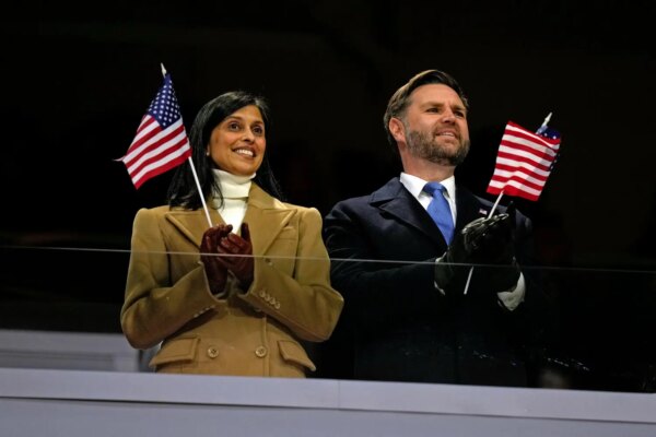 JD Vance and his wife stand in San Siro stadium in Milan and wave small American flags.