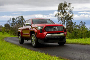 A red 2026 Toyota Tacoma on a paved roadway.