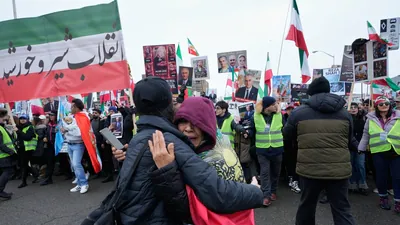 A woman comforts one of the protesters as the supporters of Iran's exiled Crown Prince Reza Pahlavi attend a demonstration in Toronto, Saturday, Feb. 14, 2026. (AP Photo/Kamran Jebreili) (AP)