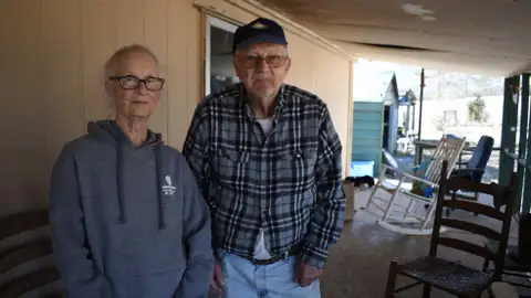 Barbara Bishop, 79, left, and her husband George Bishop, 85, pose for a portrait on their front porch,  Friday, Feb. 6, 2026 in Oxford, Ms. (AP Photo/Sophie Bates)