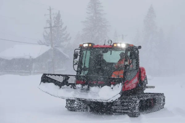 A snowcat is seen driving down the road on Donner Summit on Wednesday. (William Hale Irwin/For the S.F. Chronicle)