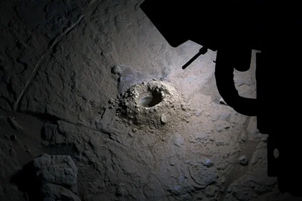 An image taken by NASA's Curiosity rover shows its LED lights lighting up a hole it drilled into the surface of the rock.