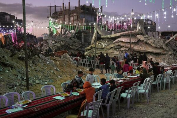 Palestinians sit at a long table amid the rubble of destroyed buildings as they gather for iftar, the fast-breaking meal, during the Muslim holy month of Ramadan in Khan Younis, Gaza Strip, Thursday, Feb. 19, 2026. (AP Photo/Abdel Kareem Hana)