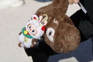 A guest wears brown fur Labubu bag with Labubu charm attached, outside Dior, during the Womenswear Spring Summer 2026 as part of Paris Fashion Week in Paris, France, on October 1, 2025.