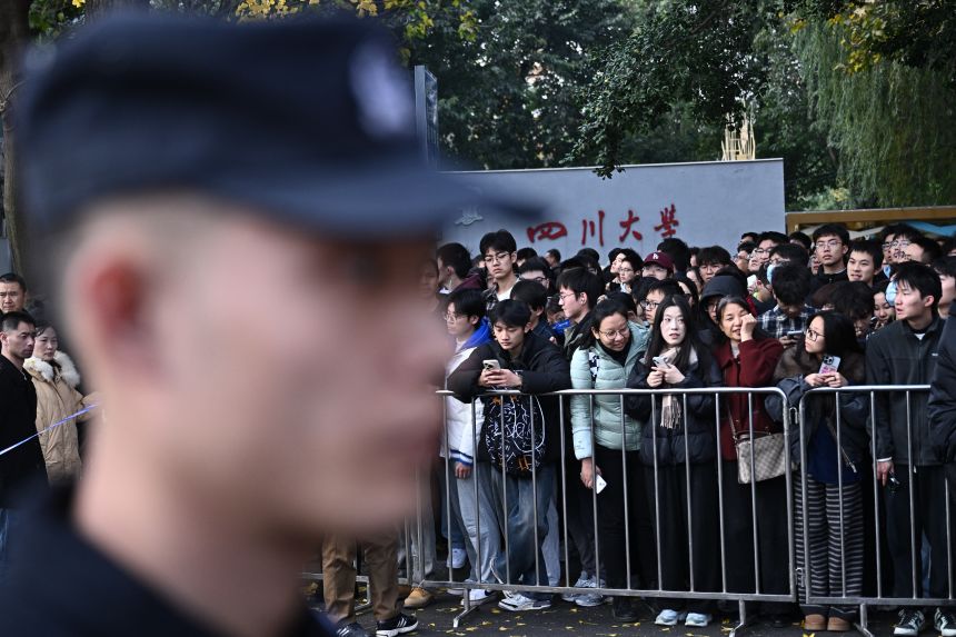 People wait for the arrival of French President Emmanuel Macron at the University of Sichuan for a meeting with students in China's Chengdu in December.