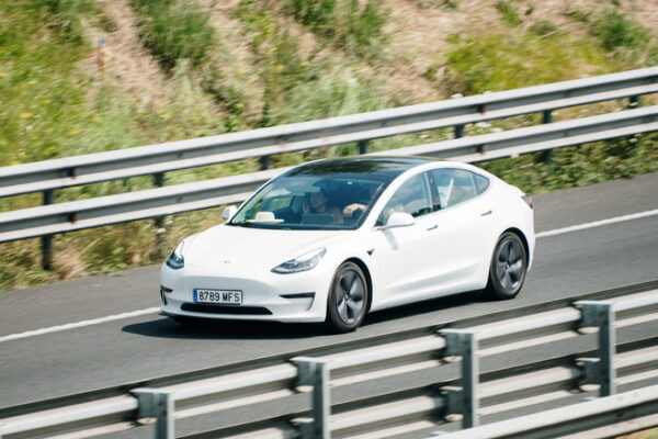 A Tesla Model 3 in motion on a highway