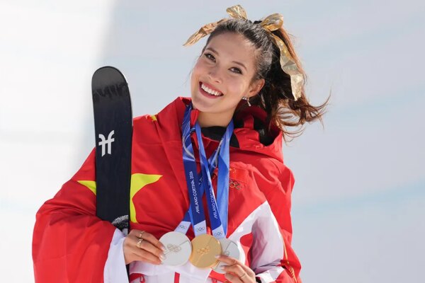 Eileen Gu smiles with her medals