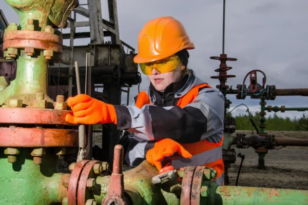 A person in protective gear working on an energy pipeline.