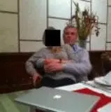 A man who looks like Andrew Mountbatten -Windsor with a young woman on his lap