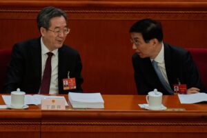 Politburo Standing Committee members Ding Xuexiang (left) and Wang Huning chat during the opening session of the National People’s Congress in Beijing, on March 5. Photo: AP