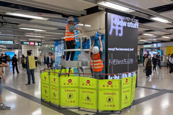 Workers remove the offending ad on Thursday night. Photo: Theads/jackyyu_6161