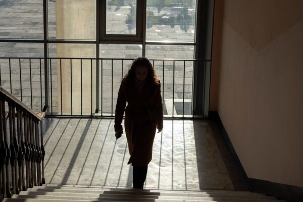 A 16-year-old Ukrainian student, Veronika, walks up a staircase inside Zlatopil Lyceum in Kharkiv region, eastern Ukraine, illuminated by daylight. She continues her education despite ongoing hostilities during the fourth year of the full-scale war.