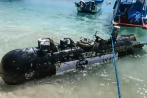 A picture taken on April 6, 2026, shows a torpedo-like 3.7-metre-long and 65-centimetre-wide object, discovered by a fisherman near the Lombok Strait after being towed ashore onto a beach on Gili Trawangan, West Nusa Tenggara. The Indonesian navy said on April 9, it was investigating a torpedo-like object discovered by a fisherman near the Lombok Strait, a key maritime route connecting the Indian and Pacific Oceans. (Photo by AFP)