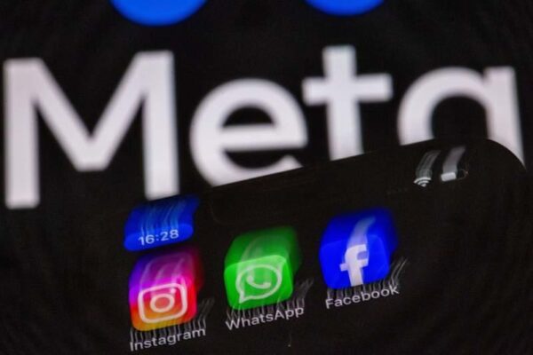 The Instagram, Facebook, and WhatsApp apps can be seen on a smartphone display in front of the logo of the internet company Meta. Jens Büttner/dpa