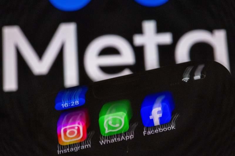The Instagram, Facebook, and WhatsApp apps can be seen on a smartphone display in front of the logo of the internet company Meta. Jens Büttner/dpa