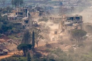 This photograph taken from the northern Israel shows Israeli tanks and military vehicles driving along the road between destroyed houses in southern Lebanon near the border with Israel. (AFP)