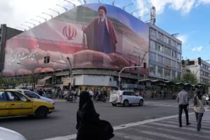 People walk past a billboard that shows a graphic depicting Iran's Supreme Leader Ayatollah Mojtaba Khamenei in downtown Tehran, Iran. (AP)